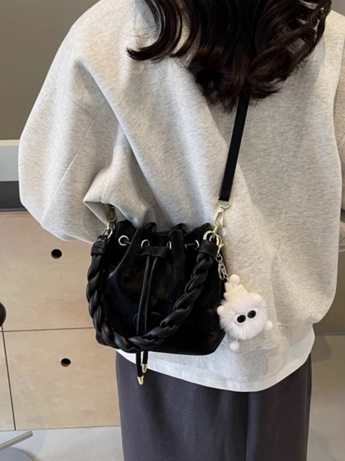 Trendsi chunky chain trim drawstring bucket crossbody bag with adjustable strap and stylish design, shown in the image.