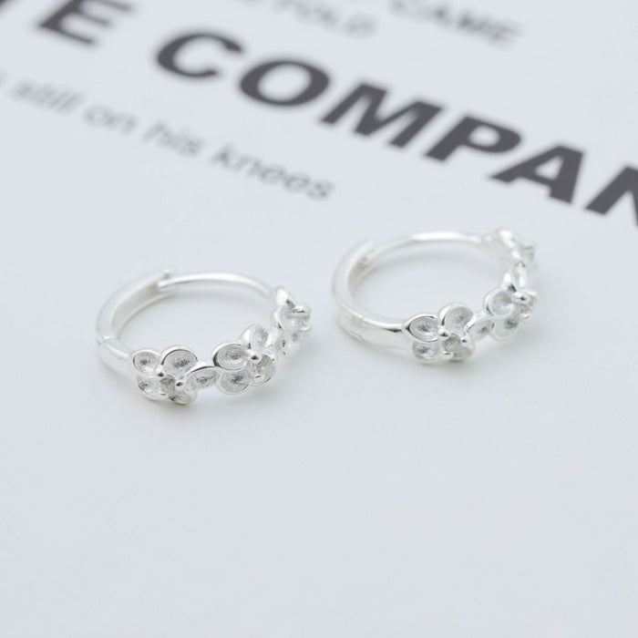 Sterling silver hoop earrings from Bloom by Trendsi, showing shiny, classic round hoops on a plain background.