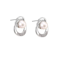 White gold-plated brass earrings with circular design, freshwater pearl center, and diamond accents