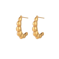 Gold-plated sculptural hoop earrings with chunky segmented design on cream background