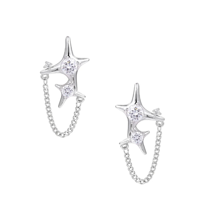 Silver star studs with crescent moon cutouts and zirconia stones connected by delicate chains on white background