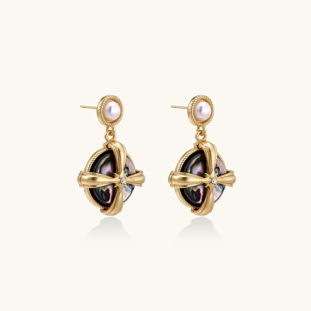 Gold-plated drop earrings with iridescent abalone shell and pearl studs in geometric cross design