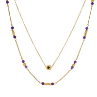 Two layered gold-tone necklaces with purple stone beads and star pendant against cream background.