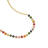 Colorful four-leaf clover jewelry set with rainbow cubic zirconia stones in gold-plated setting on white background