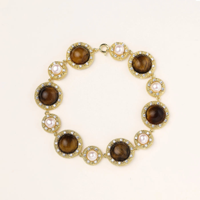 Gold-plated link bracelet with alternating brown tiger's eye stones and white freshwater pearls in ornate bezels.