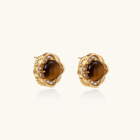 Gold-plated stud earrings with ornate floral frames surrounding cabochon tiger's eye stones and zirconia accents