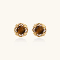 Gold-plated stud earrings with ornate floral frames surrounding cabochon tiger's eye stones and zirconia accents