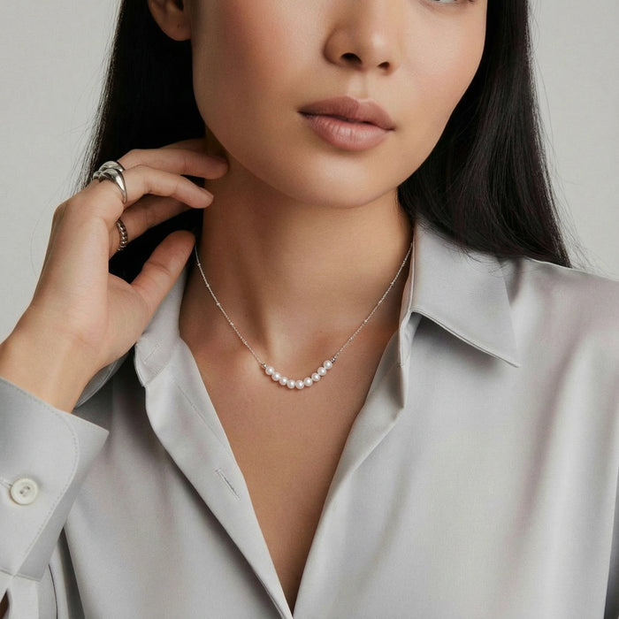 Luna Pearl Arc Necklace from The Glambox Jewels Boutique featuring a delicate gold chain with pearl accents.