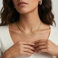 Gold layered necklace from The Glambox Jewels Boutique featuring multiple delicate chain layers with a shiny finish.