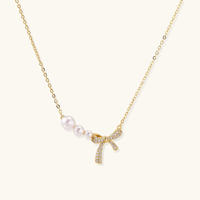 Pearl Bow Dreams Necklace from The Glambox Jewels Boutique featuring a delicate pearl and bow pendant on a fine chain.