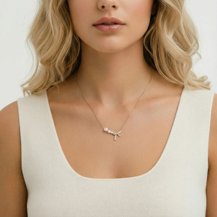 Pearl Bow Dreams Necklace from The Glambox Jewels Boutique featuring a delicate pearl and bow design on a silver chain.