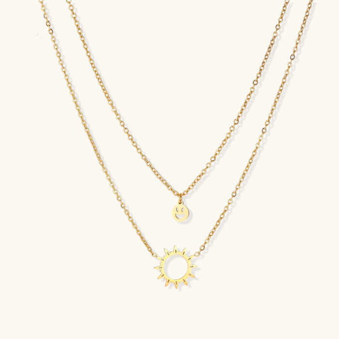 Gold layered Sunshine Smiley necklace by The Glambox Jewels Boutique featuring cheerful sun and smiley charm design.
