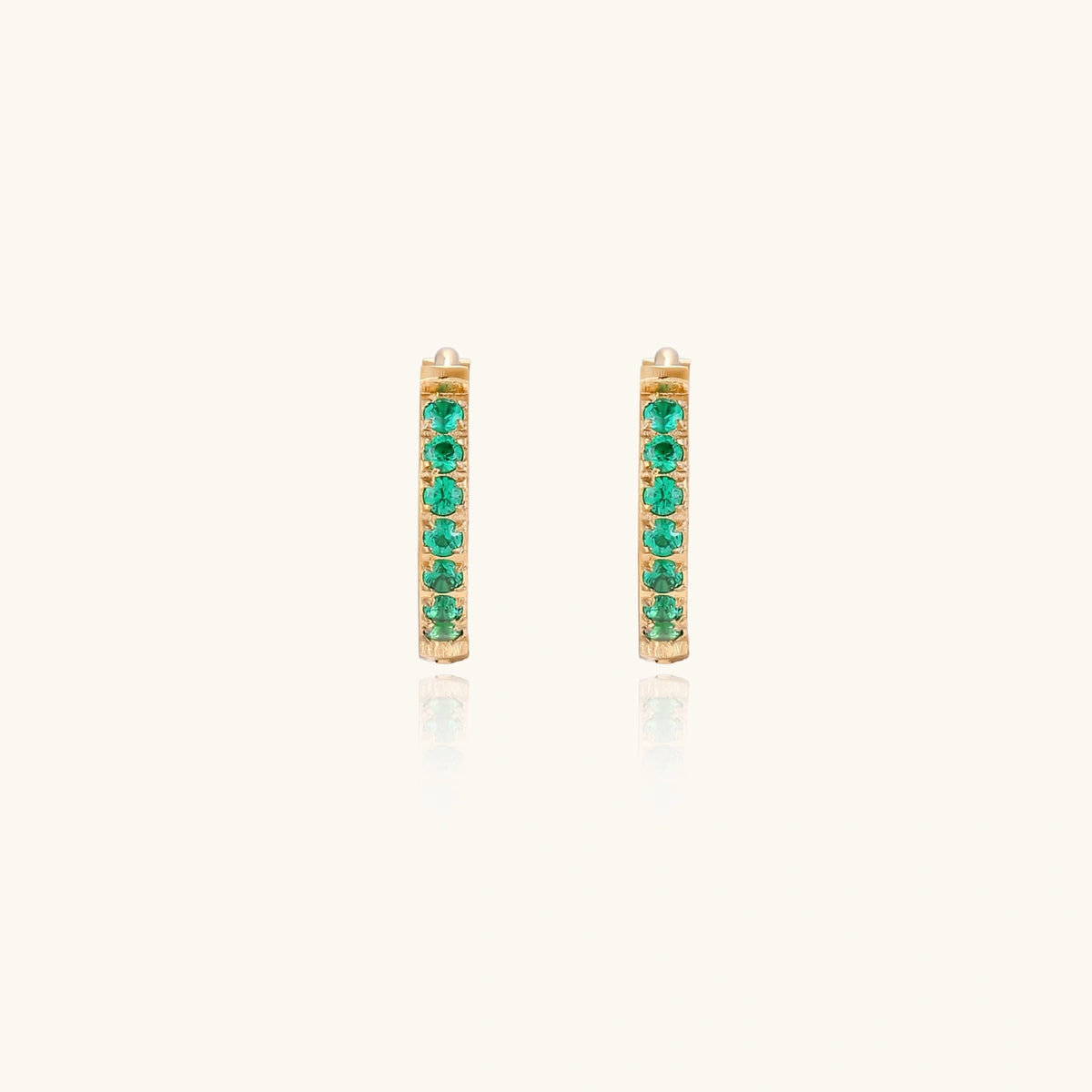Emerald Energy Huggies earrings by The Glambox Jewels Boutique featuring vibrant green gemstone hoops on a silver setting.