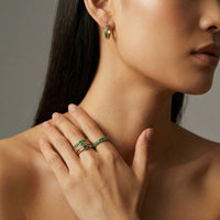 Emerald Energy Huggies earrings by The Glambox Jewels Boutique featuring vibrant emerald green gemstone accents and gold-tone metal.