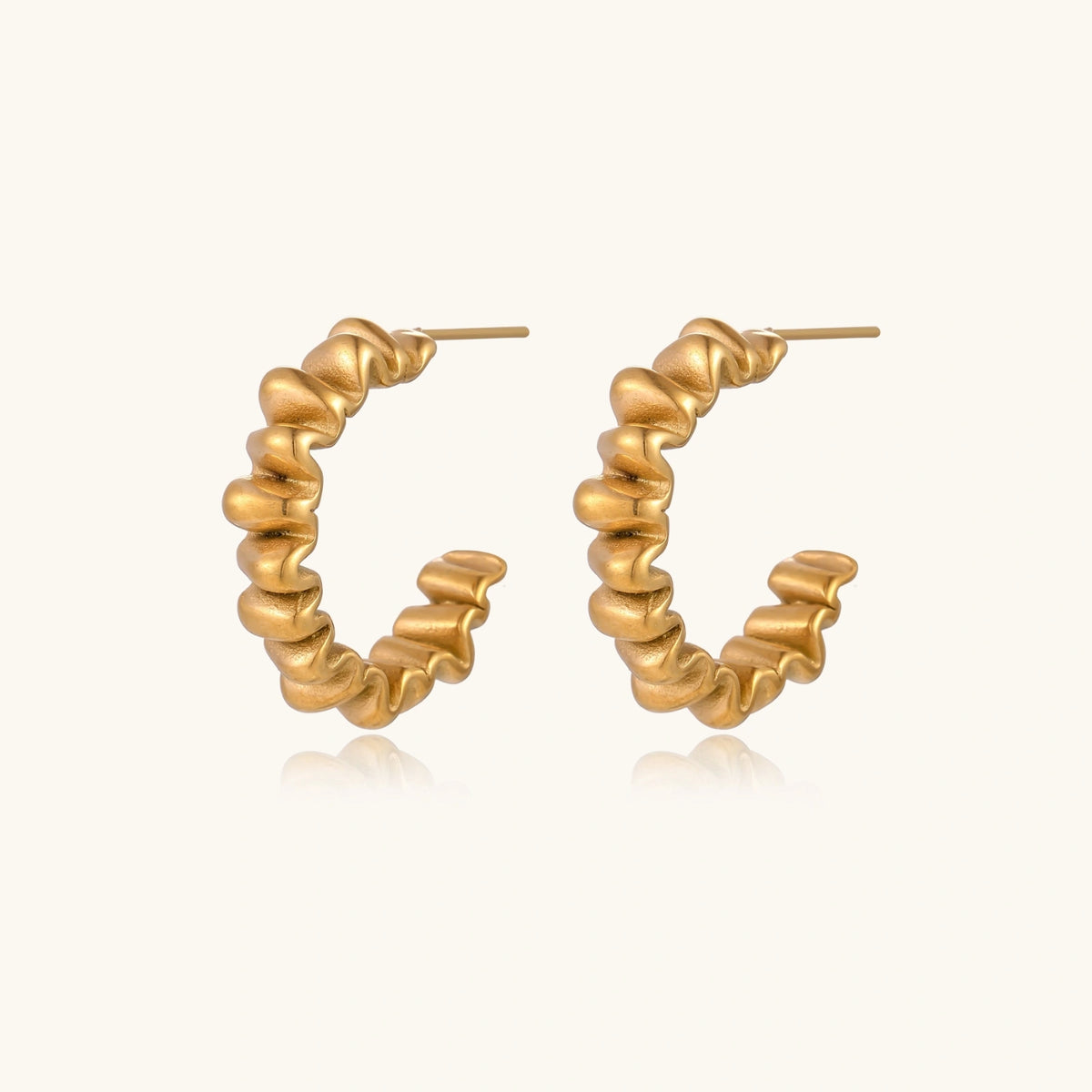 Twisted gold hoop earrings from The Glambox Jewels Boutique featuring a sleek, modern design for stylish accessorizing.