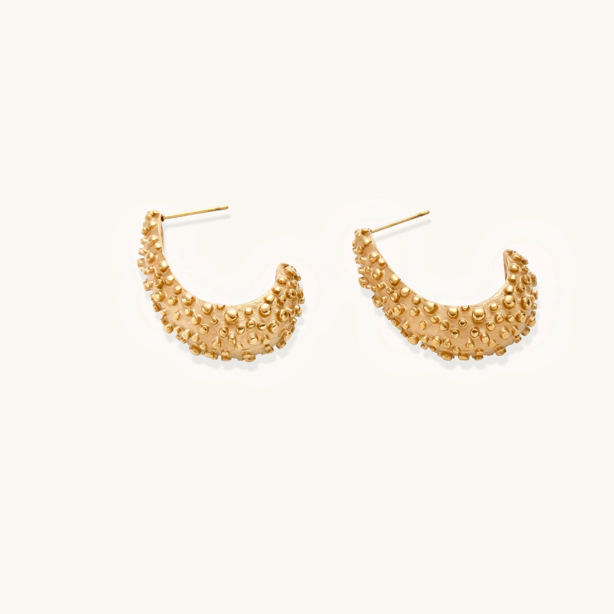 Textured crescent hoop earrings by The Glambox Jewels Boutique, showcasing a stylish, modern design in a close-up image.