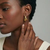 Sculpted drop earrings from The Glambox Jewels Boutique featuring elegant, curved design in gold-tone metal.
