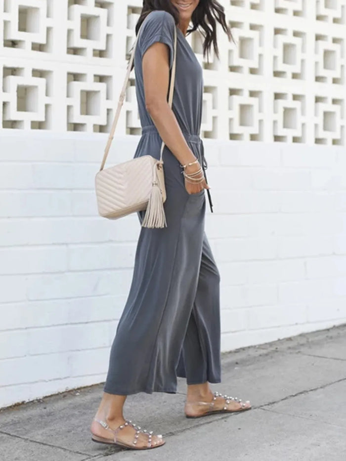 Black tie-waist V-neck jumpsuit with pockets from Trendsi, featuring a stylish V-neck and comfortable fit.