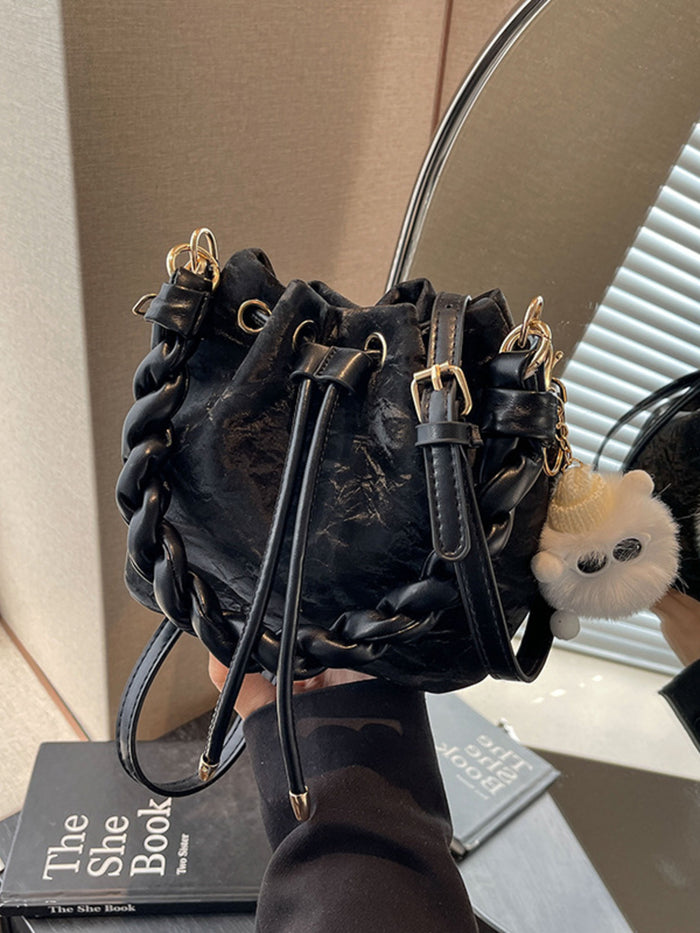 Trendsi Chunky chain trim drawstring bucket crossbody bag with adjustable strap and stylish design, featuring a spacious interior.