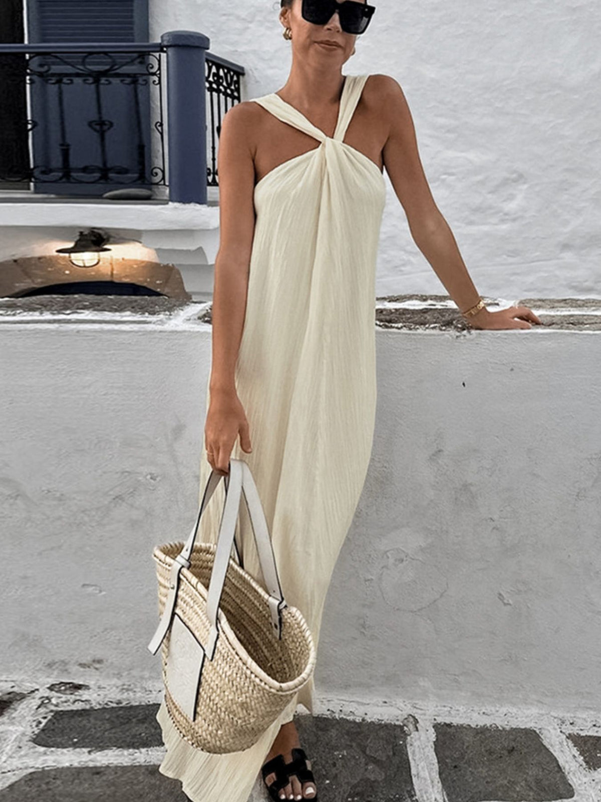 Halter neck maxi dress by Trendsi featuring flowing fabric and sleeveless design, perfect for summer or formal occasions.