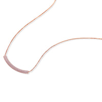 Rose gold jewelry set with pavé cubic zirconia stones including curved necklace, hoop earrings, and adjustable ring on cream background.