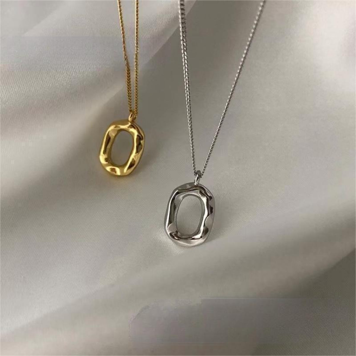 Sterling silver geometric pendant necklace with 18K gold plating, featuring a modern design on a delicate chain