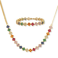 Colorful four-leaf clover jewelry set with rainbow cubic zirconia stones in gold-plated setting on white background