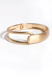 SAACHI overlap hinged bracelet featuring a stylish, polished metal design with a secure hinge closure.