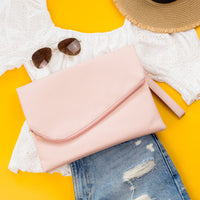 Blush pink foldover envelope clutch handbag by Aili's Corner with sleek, minimalist design and foldover flap.