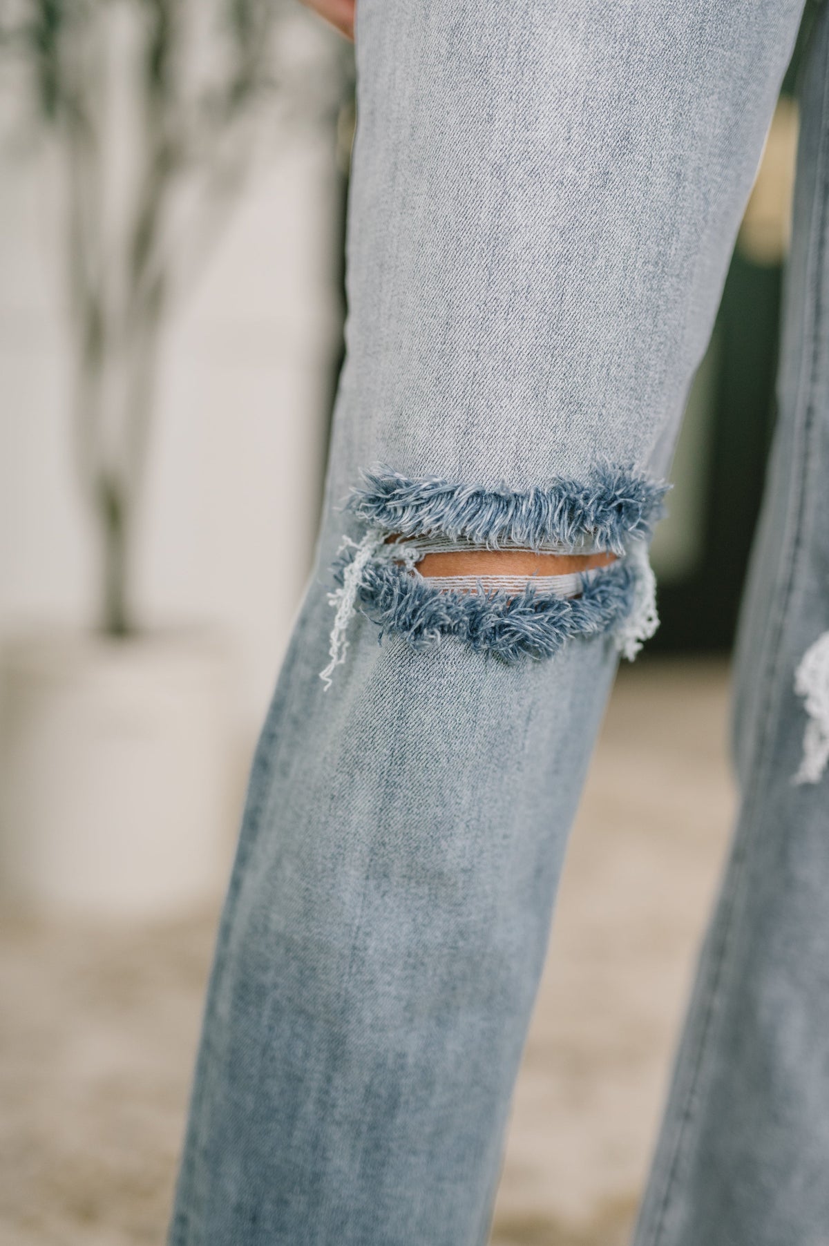 Light-wash Elaine mid-rise boyfriend jeans with distressed details and cuffed hems, styled by Ave Shops.
