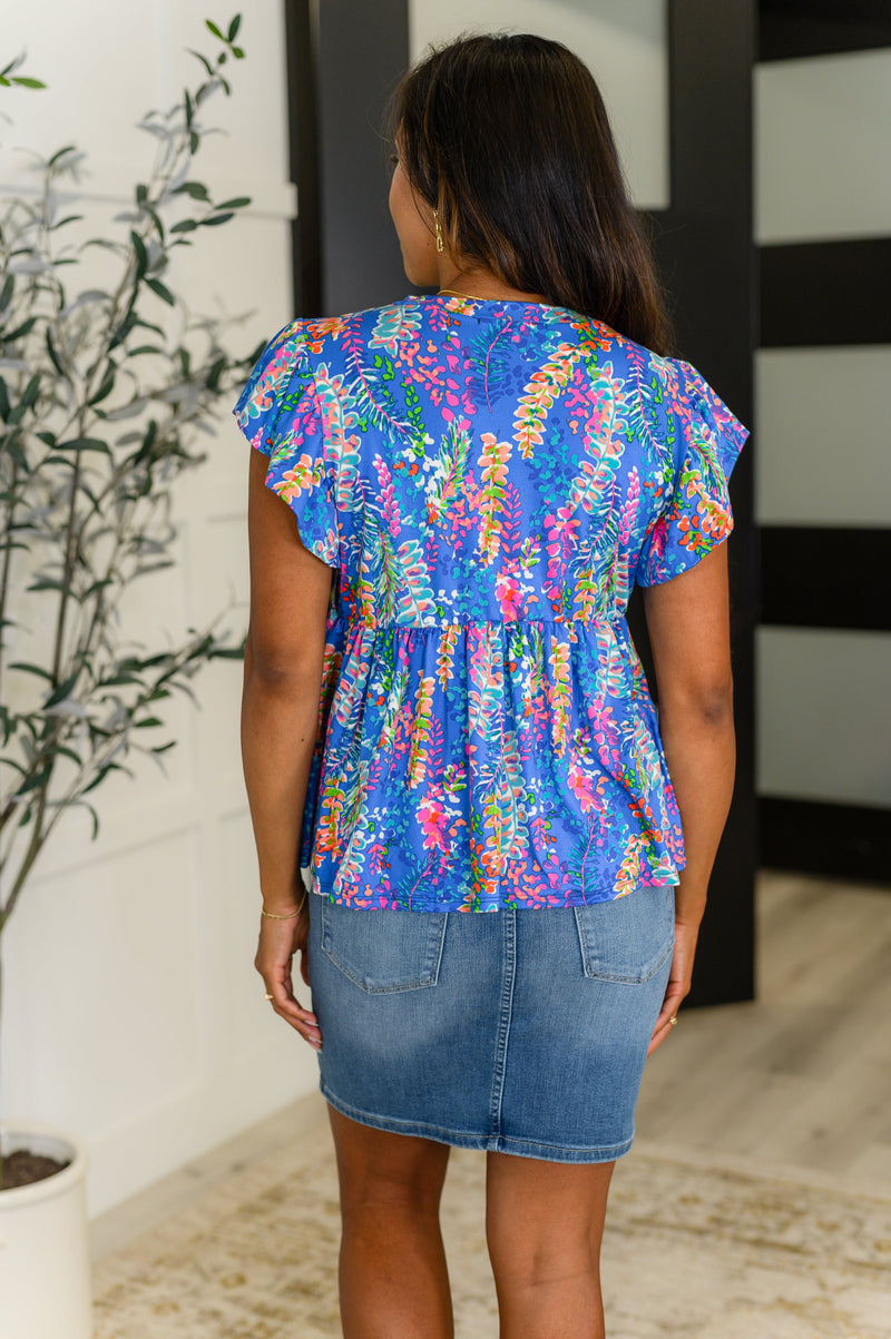 Top azul con mangas onduladas y alerta de coqueteo