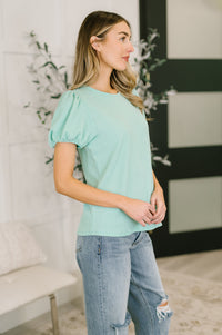 Mint-colored Grace & Virtue balloon sleeve blouse with puffed sleeves and a relaxed fit, styled on a model.