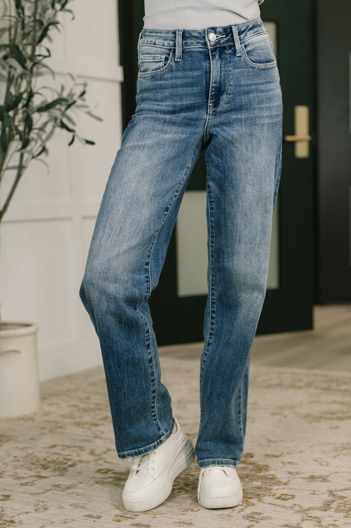 Light blue Ave Shops Holly Mid Rise Straight jeans displayed on a hanger, showcasing classic fit and clean denim design.