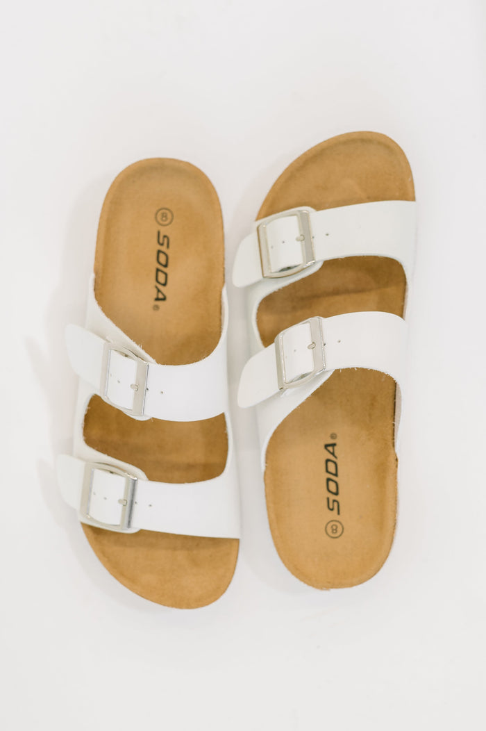White Ave Shops Jete Double Buckle Slides shoes with two adjustable buckles and a sleek, modern design.