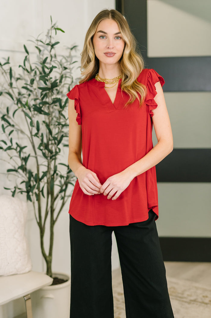 Red Lizzy flutter sleeve V-neck blouse by Ave Shops, featuring flowing fabric and stylish design.