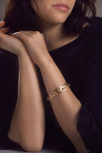 Beaded botanical hook bracelet by SAACHI featuring colorful beads and intricate design on a natural background.