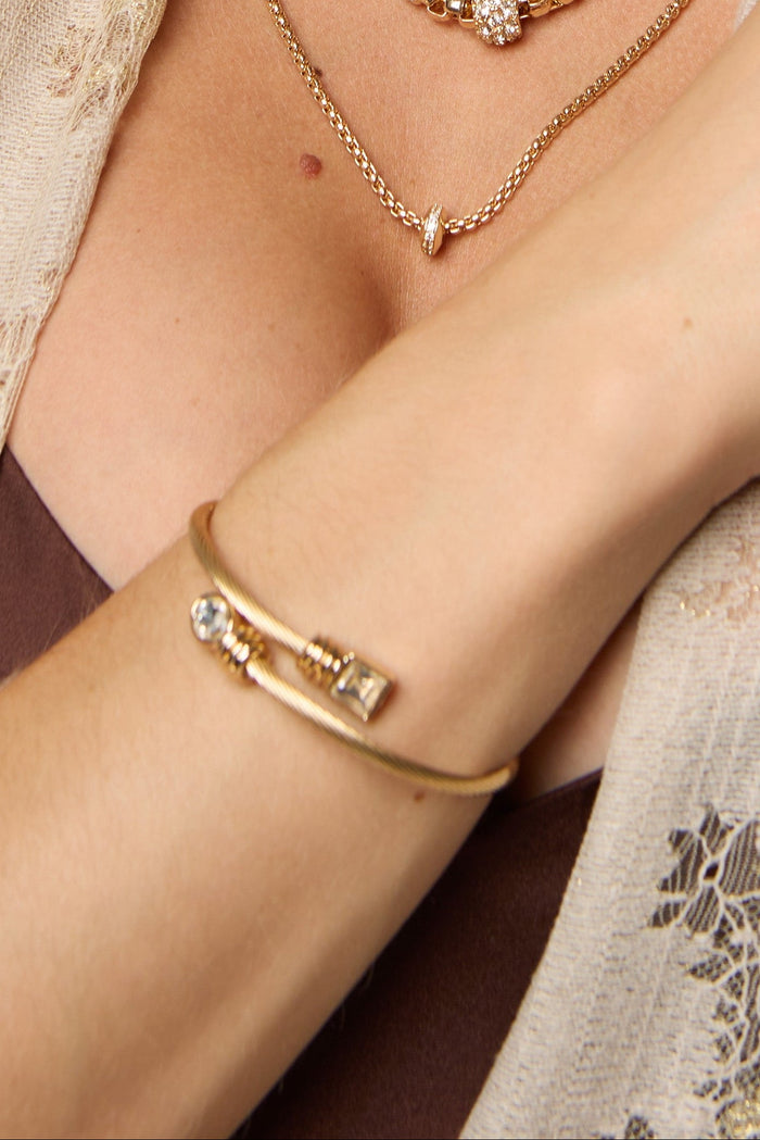 Golden Twist Gem Cuff bracelet by SAACHI featuring a metal design with gemstone accents, styled as a statement jewelry piece.