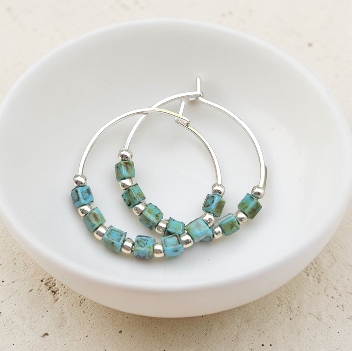 Silver and turquoise beaded hoop earrings from Bijou by SAM featuring boho-style silver and turquoise accents.