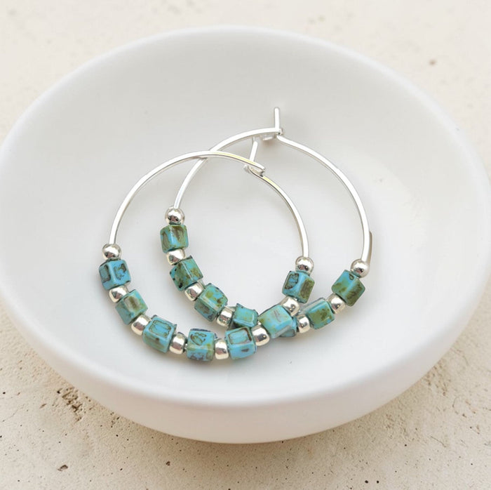Silver and turquoise beaded hoop earrings from Bijou by SAM featuring boho-style silver and turquoise accents.