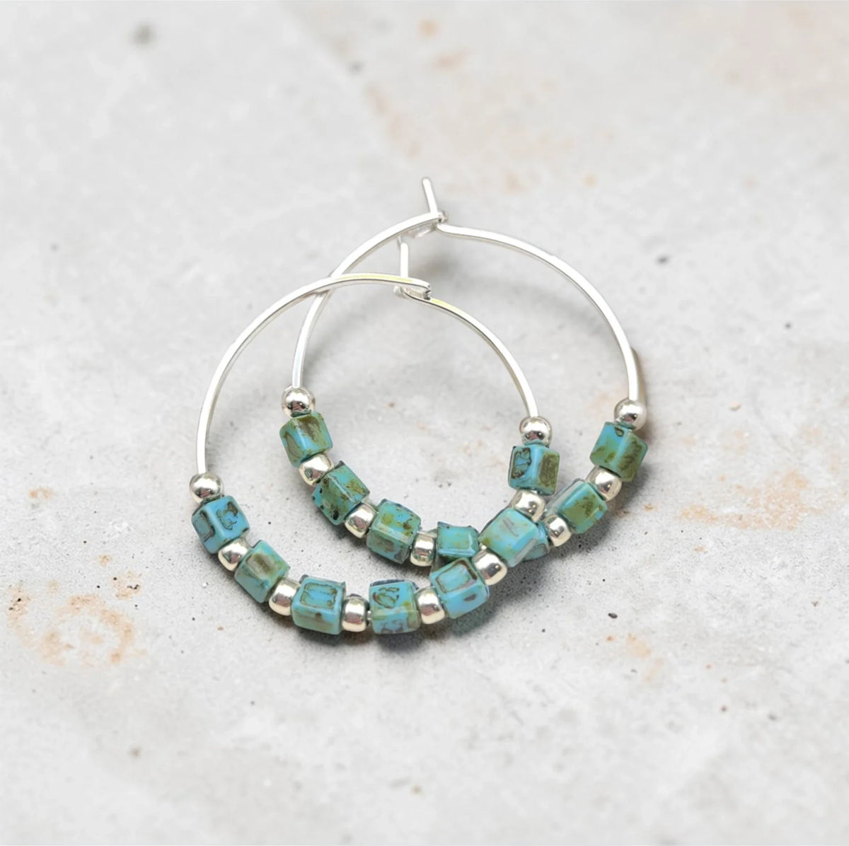 Silver and turquoise beaded hoop earrings from Bijou by SAM featuring boho-style silver and turquoise accents.