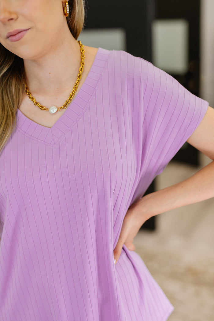 Lavender V-neck ribbed tee from Top Shelf Basic by Ave Shops, showcasing a fitted blouse with a V-neck and ribbed knit fabric.