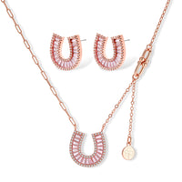 Sparkling horseshoe-shaped jewelry set with AAA cubic zirconia in gold-plated and white gold finishes on cream background.