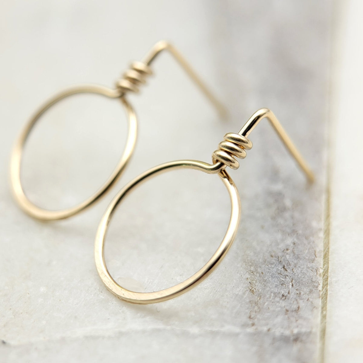 Small gold circle stud earrings from Bijou by SAM, featuring sleek, minimalist design with a polished finish.