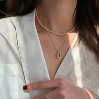 Sterling silver geometric pendant necklace with 18K gold plating, featuring modern design, on a delicate chain.