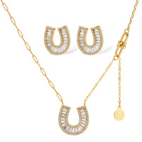 Sparkling horseshoe-shaped jewelry set with AAA cubic zirconia in gold-plated and white gold finishes on cream background.