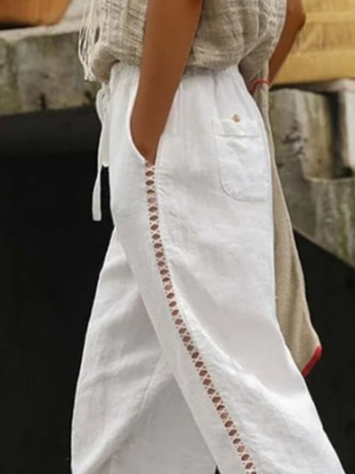 Hollow out trim cropped pants in black with a stylish cut-out design, trendy pants by Trendsi shown on a model.