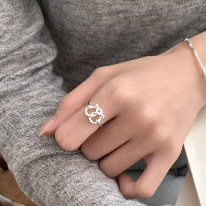 Eternal Knot Heart Ring by Trendsi featuring a silver band with an intricate heart-shaped knot design.