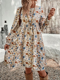 Floral print long sleeve tiered dress from Trendsi, featuring a feminine design with layered tiers and vibrant floral pattern.
