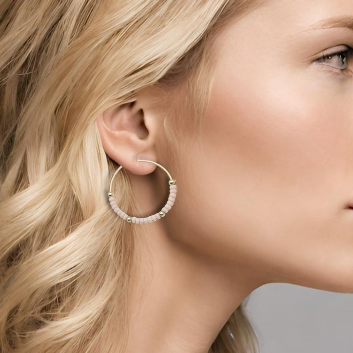 Gold hoop earrings with pale pink accents from Bijou by SAM's Boho collection, featuring stylish and lightweight jewelry design.