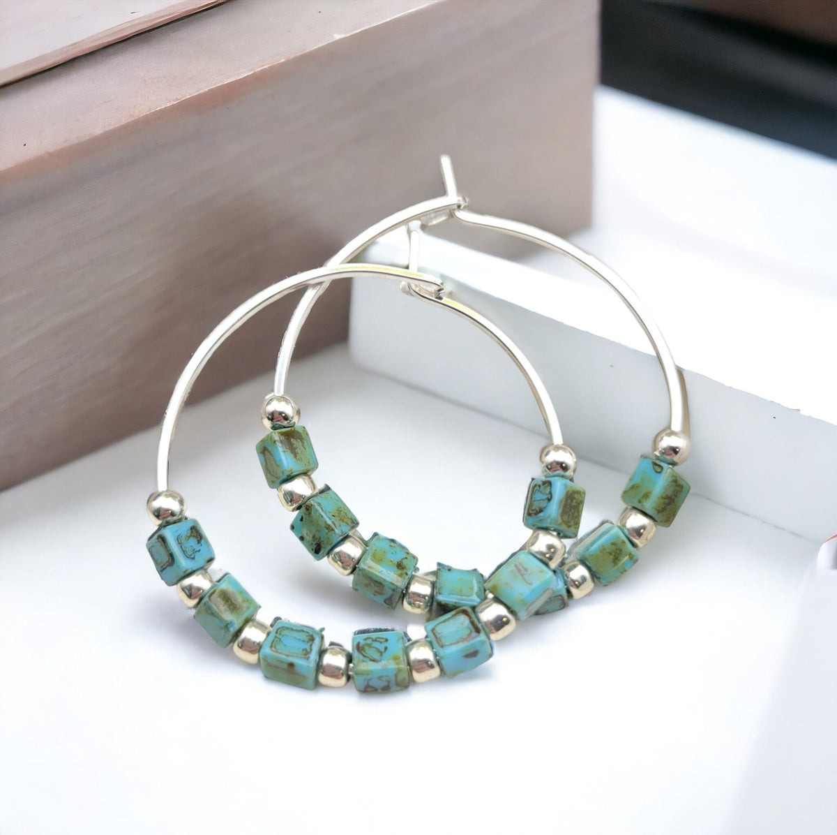 Silver and turquoise boho hoop earrings by Bijou by SAM featuring intricate detailing and vibrant color accents.